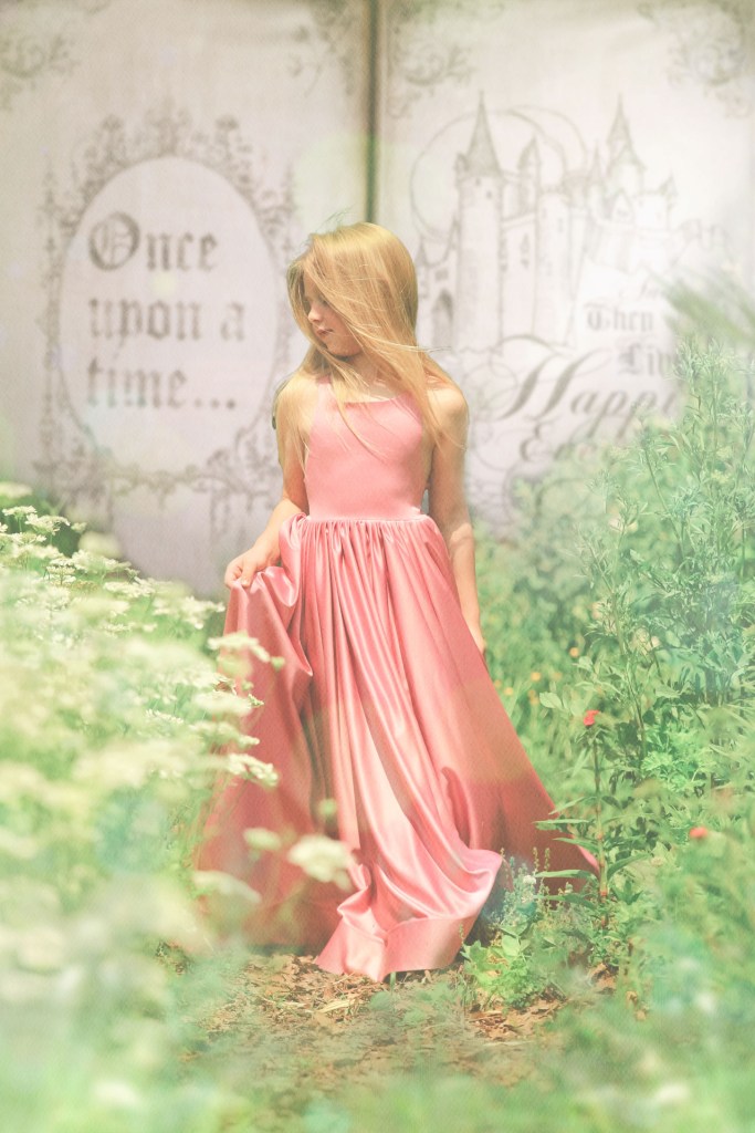 girl walking through Dahlia & Vine Flower Farm with storybook background