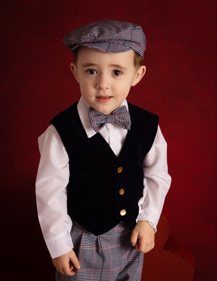 young boy studio portrait on red background in Lusby